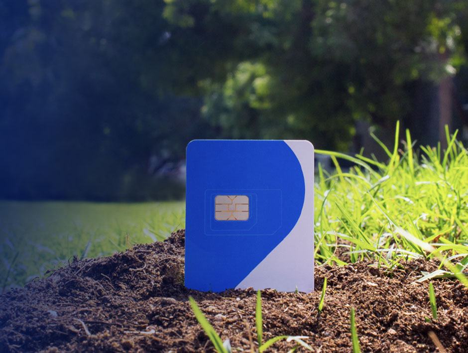 A biodegradable SIM card rests on the grass, symbolising its eco-friendly nature